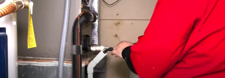 A service worker cleans out an AC unit.