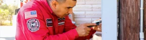 Jon Wayne technician in red uniform performing electrical panel inspection and repairs on residential home.