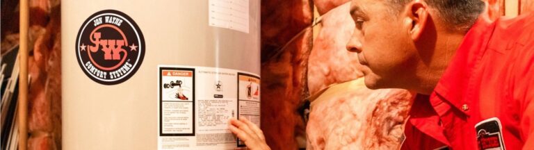 A service worker examines a water heater